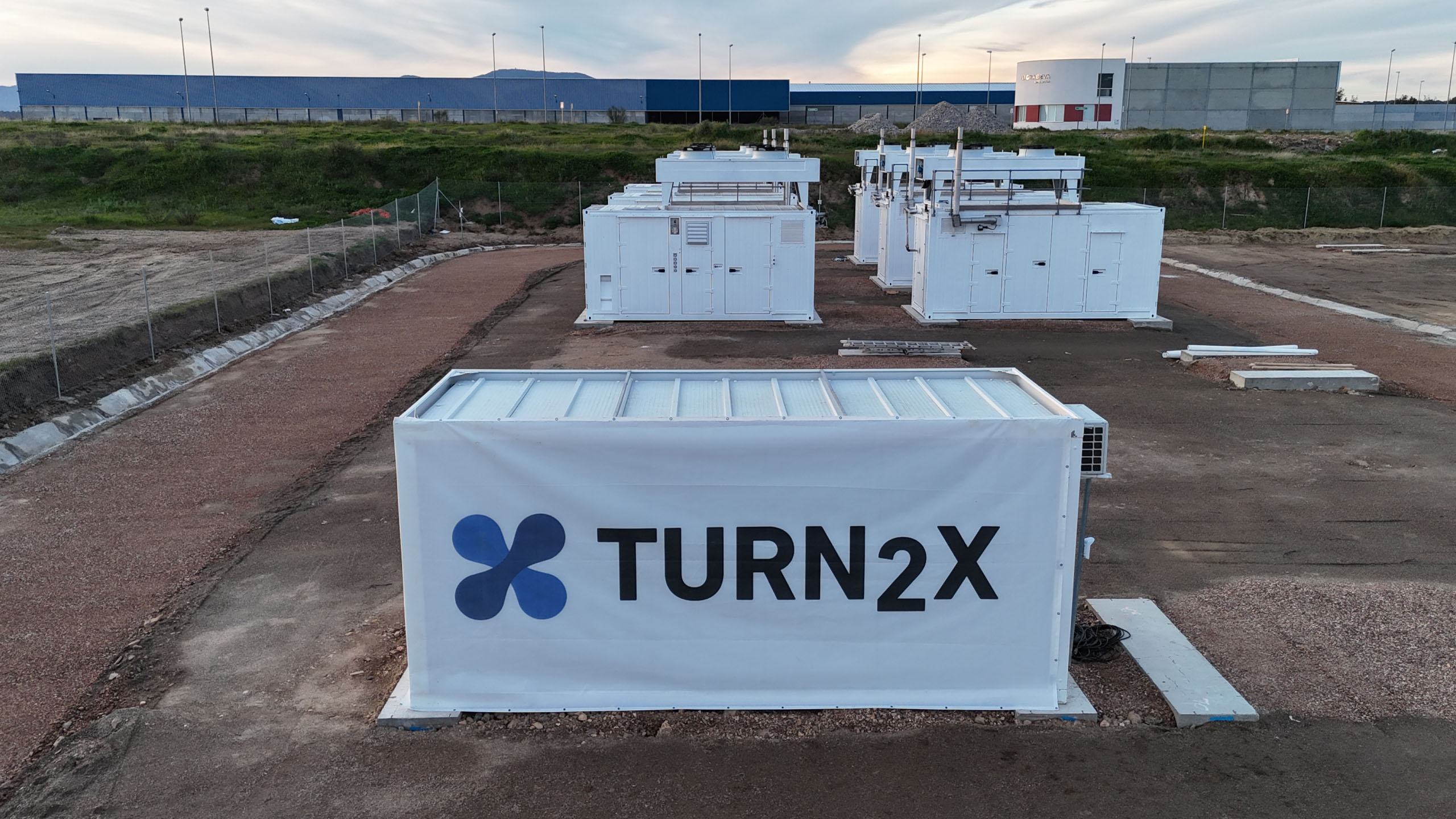 Close-up view of TURN2X's first commercial plant in Miajadas, Spain, with joined facilities in the background.
